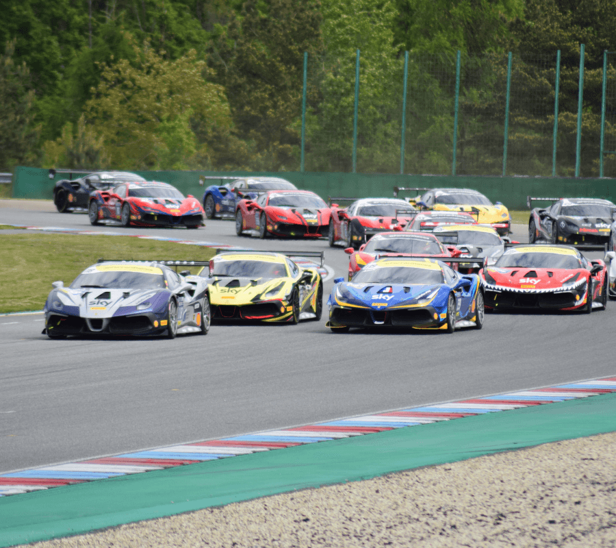 A group of colorful race cars speeding around a track.